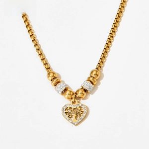 Close-up of golden heart pendant with Tree of Life design and sparkling cubic zirconia stones