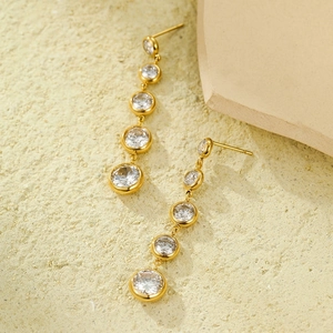 Macro view of gold tassel earrings with five graduated round cubic zirconia stones