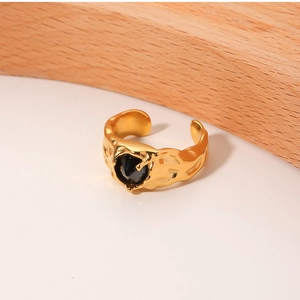 Detailed view of vintage gold molten texture ring featuring a black teardrop gemstone