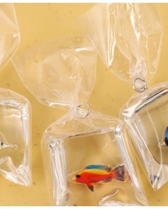 Détail du pendentif poisson en résine montrant le trou rond de 4 mm pour porte-clés