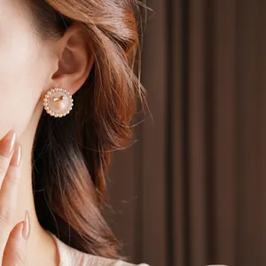 Elegant vintage pearl stud earrings featuring a golden bow motif for a retro classic look