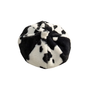Plush cow print beret hat for women with a soft textured black and white animal pattern