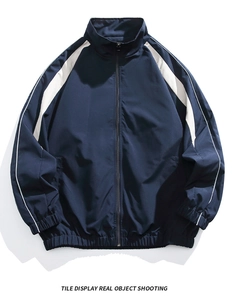 Detail of navy blue standing collar jacket with white stripes and elastic cuffs