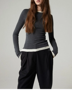 Detailed view of women's slim-fit knit sweater with contrast white collar and hem