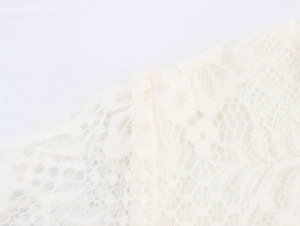 Macro shot of elegant white lace fabric with intricate floral patterns and fine mesh