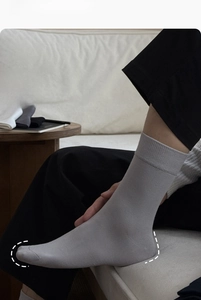 Close-up of light grey crew socks featuring elastic ribbed cuffs and reinforced toe support