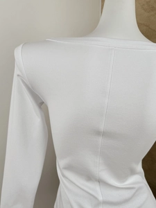 Detailed close-up of white ribbed knit fabric texture and vertical back seam stitching