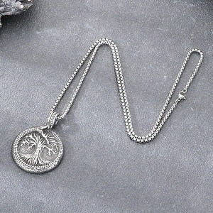 Detail of vintage silver Jormungandr World Tree pendant with a square pearl chain