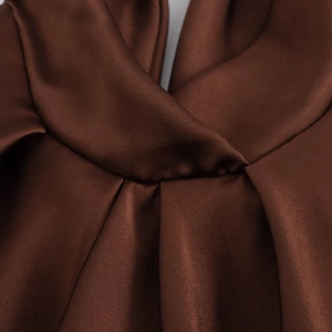 Detail of the brown satin midi dress showing elegant pleated neck and smooth silk texture