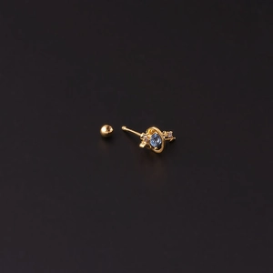 Puce d'oreille planète dorée avec zircon bleu et petits cristaux sur fond sombre