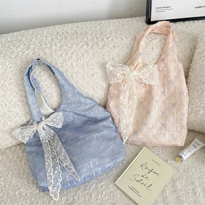 Détail de sacs fourre-tout en résille bleus et roses avec motifs de nœuds et dentelle