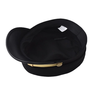 Détail d'un béret noir avec bord doré, étiquette de taille 58 et mélange de coton