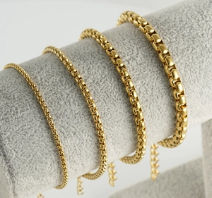 Comparison of four different thicknesses of golden square venetian chain bracelets on a stand