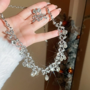 Sparkling silver jewelry set with bow and teardrop crystals held by hand