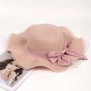 Summer wide brim straw sun hat with pink ribbon bow and pearl beads for beach vacations