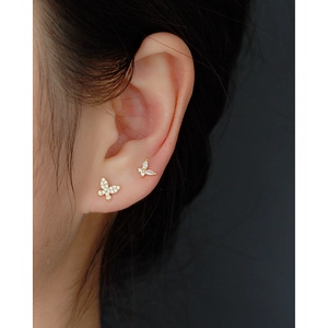 Colorful zircon butterfly stud earrings in gold finish worn by model in a close-up shot