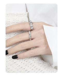 Detail of S925 sterling silver rings with crystals on model in white knitwear