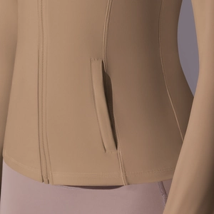 Detail of hidden zipper pocket and flatlock seams on nylon hooded yoga jacket