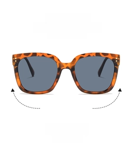 Detail of tortoise shell oversized square sunglasses with gold rivet accents and grey lenses