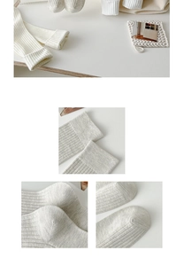 Detailed knit texture of cream and grey knee-high cotton socks with vertical stripes