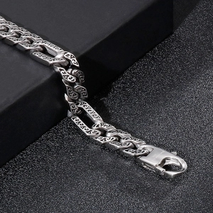 Close-up of vintage engraved silver Cuban link bracelet with S925 hallmark on clasp
