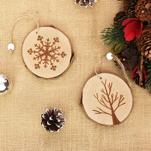 Natural wood Christmas ornaments with laser-engraved snowflakes on rustic beige linen