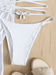 Flachbild des weißen 4-teiligen Bikinis mit Kreuzgurt-Höschen und Netzrock