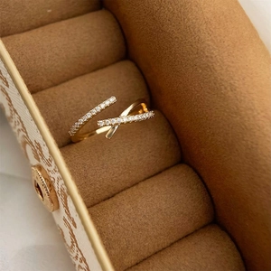 Macro detail of French style gold-plated crisscross ring with pavé zircon setting
