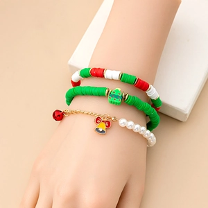 Detailed close-up of a Christmas themed 3-piece bracelet set worn on a female wrist