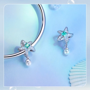 Macro shot of silver starfish charm with blue zircon and pearl for DIY jewelry
