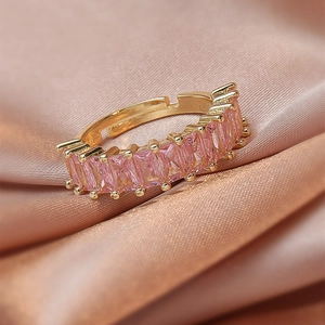 Macro view of adjustable gold ring featuring rectangular pink zircon stones on silk