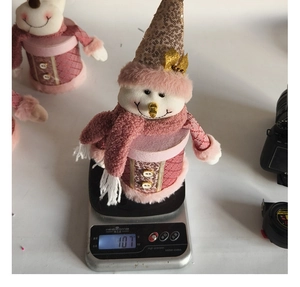 Detailed view of pink snowman gift box showing weight of 107g on electronic scale