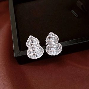 Macro shot of silver gourd-shaped clip earrings encrusted with sparkling zircon stones