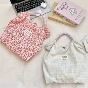 Flat lay of floral and checkered canvas tote bags with colorful braided rope handles