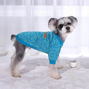 Close-up of a blue knit pet sweater with a brown leather Classic tag on the side