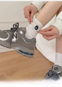 Detailed view of white cotton mid-calf socks with cute cat embroidery and colorful flecks