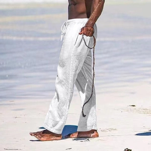 Detail of white linen blend trousers with drawstring waist on beach background