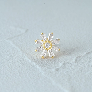 Macro shot of gold s925 silver ear stud with snowflake gem pattern and flat back