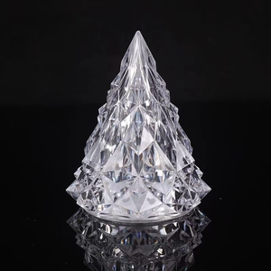 Macro detail of clear crystal Christmas tree lamp with faceted edges on reflective surface