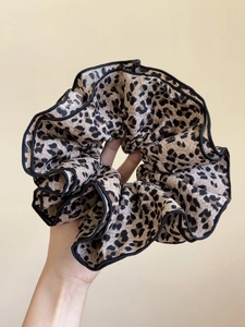 Dettaglio macro dell'elastico per capelli leopardato con bordi neri cuciti di alta qualità