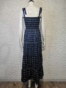 Detail of navy maxi dress with white dot print, smocked back and tiered skirt on a mannequin