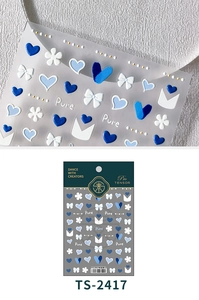 Macro shot of 3D blue heart and bow nail art stickers with delicate embossed textures
