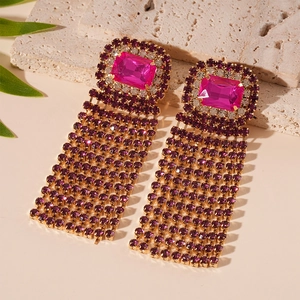 Detail of luxury square earrings with rose red stones and purple rhinestone tassels
