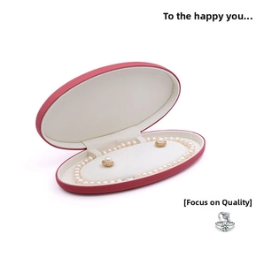 Detail of oval pink velvet jewelry box containing white pearl necklace and earring set
