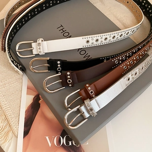 Detail of vintage studded leather belts with rhinestones and punk metal eyelets