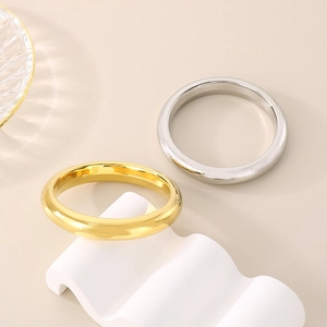 Detailed view of wide 13mm polished stainless steel bangles in gold and silver finish