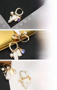 Detail of 18K gold-plated hoop earrings featuring natural pearls and purple teardrop beads