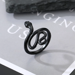Detailed view of a matte black gothic snake ring on a minimalist stone display