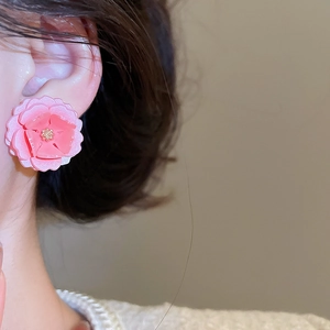 Vue détaillée de la boucle d'oreille fleur rose 3D avec centre doré sur un modèle