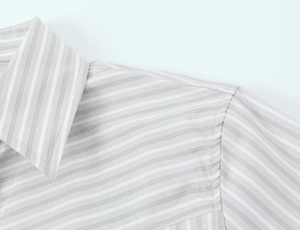 Gros plan détaillé des rayures verticales et des coutures sur la chemise grise